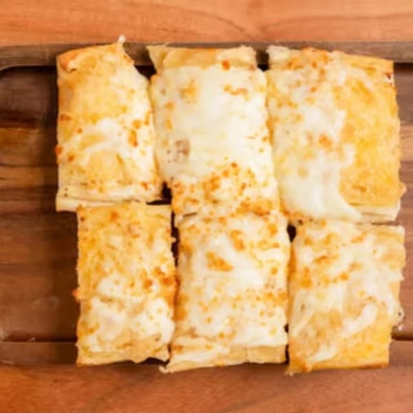 Six rectangular pieces of cheesy bread, golden brown and topped with melted white cheese, on a wooden board.